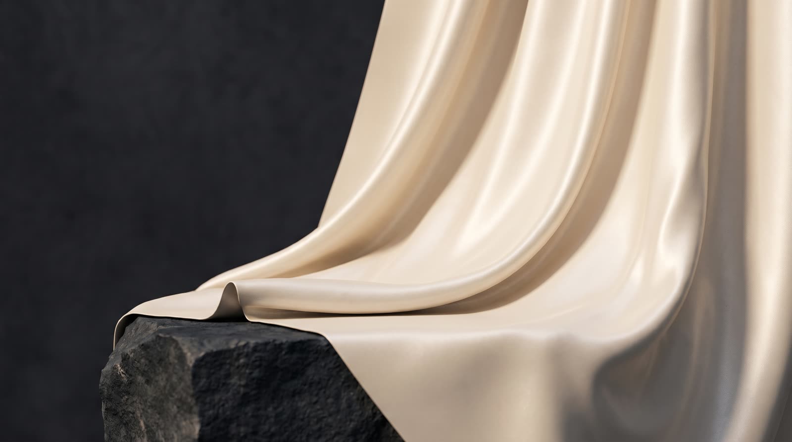 Ivory silk fabric draped over a dark stone pedestal